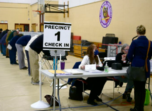 people voting on election day at voting booths at the elementary school gym a gym in Williamstown